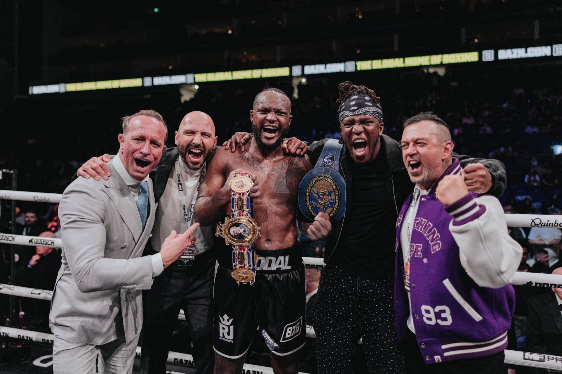 Viddal Riley celebrating a championship victory in the ring with his team